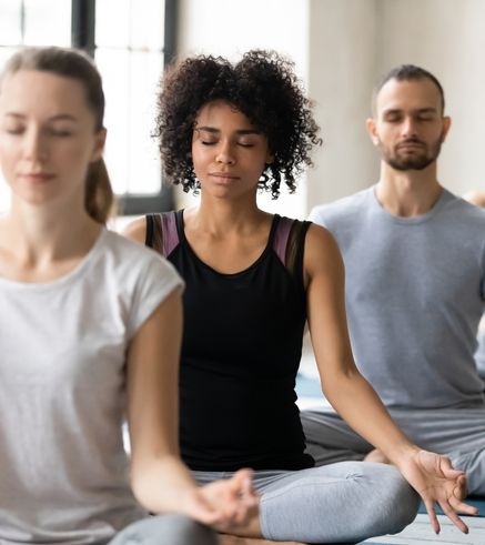 Group of members practicing yoga and meditation in a fitness class at Everyone Fitness gym